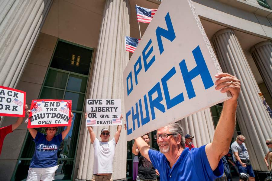 Demonstrators hold signs demanding their church to reopen during a rally to re-open California on May 1, 2020, in San Diego. (SANDY HUFFAKER/AFP via Getty Images)