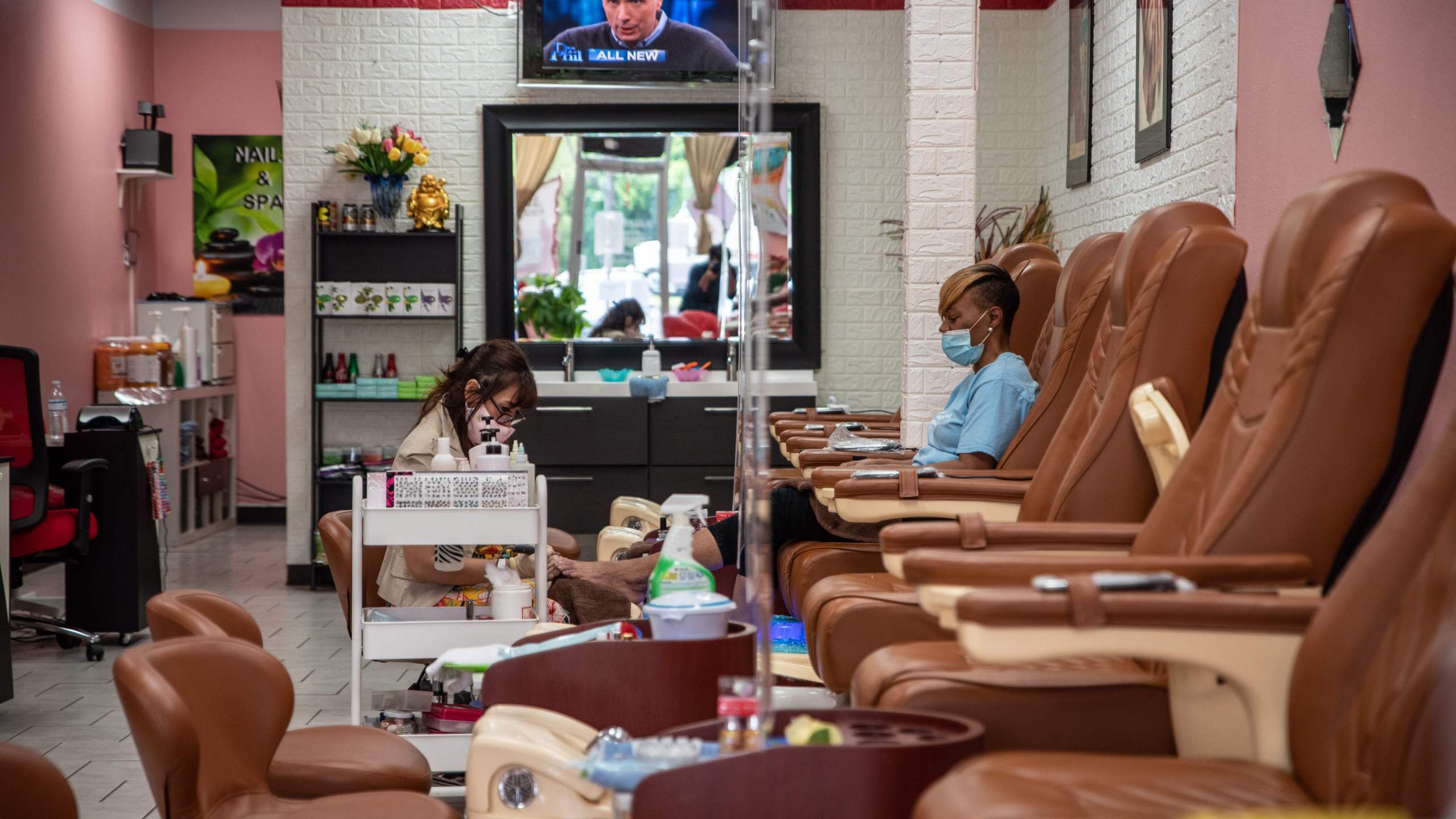 A worker paints a woman's nails at a nail salon amid the coronavirus pandemic in Austin, Texas, on May 8, 2020, following a slow reopening of the economy. (Sergio Flores / AFP / Getty Images)