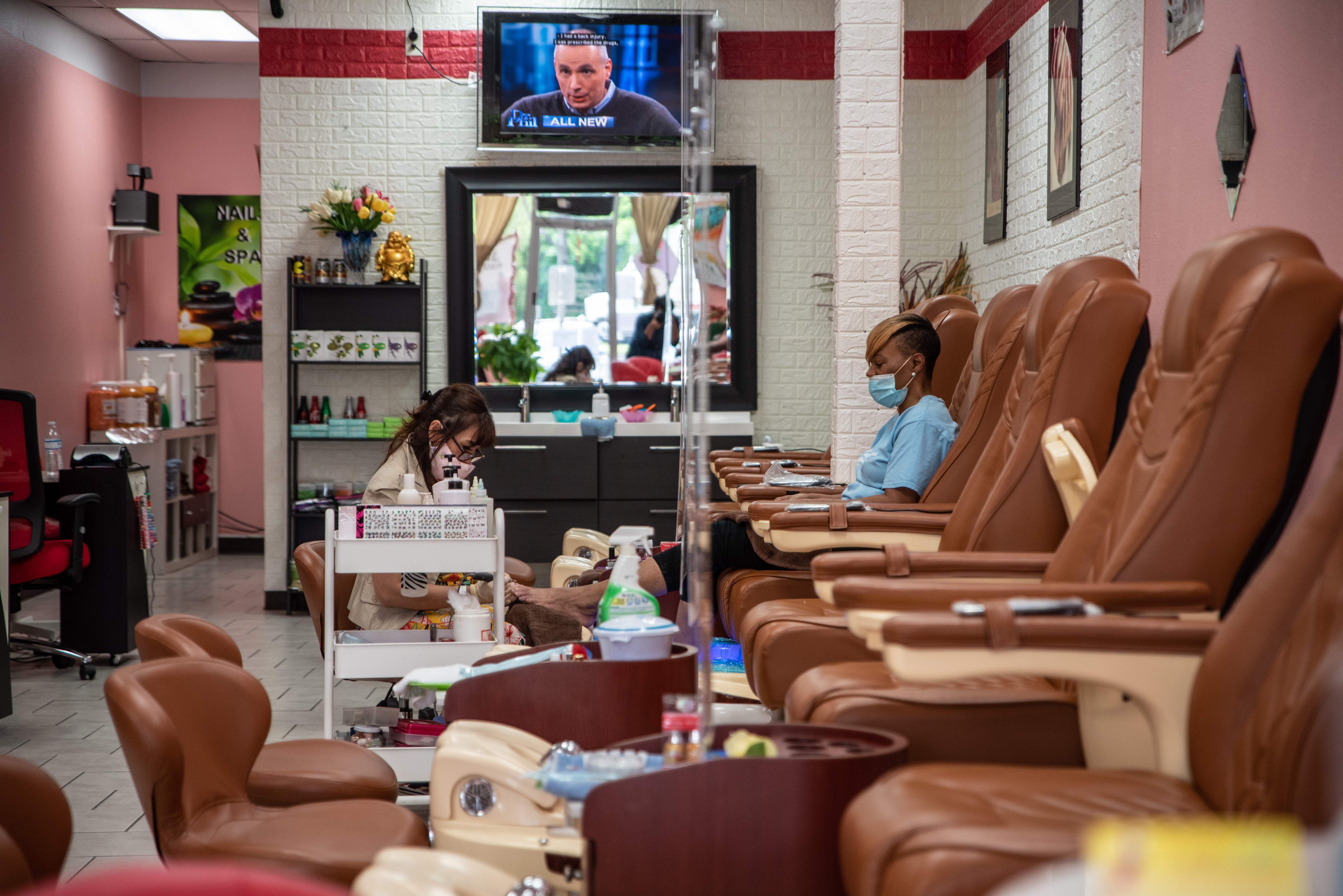 A worker paints a woman's nails at a nail salon amid the coronavirus pandemic in Austin, Texas, on May 8, 2020, following a slow reopening of the economy. (Sergio Flores / AFP / Getty Images)