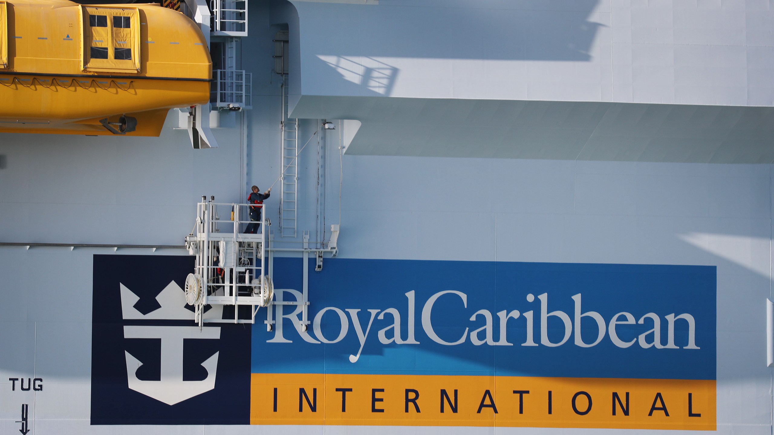 A worker paints the side of the Royal Caribbean Symphony of the Seas cruise ship, which is the world's largest passenger liner, as it is docked at Port Miami after returning to port from a Eastern Caribbean cruise as the world grapples with the coronavirus outbreak on March 14, 2020 in Miami, Florida. (Joe Raedle/Getty Images)