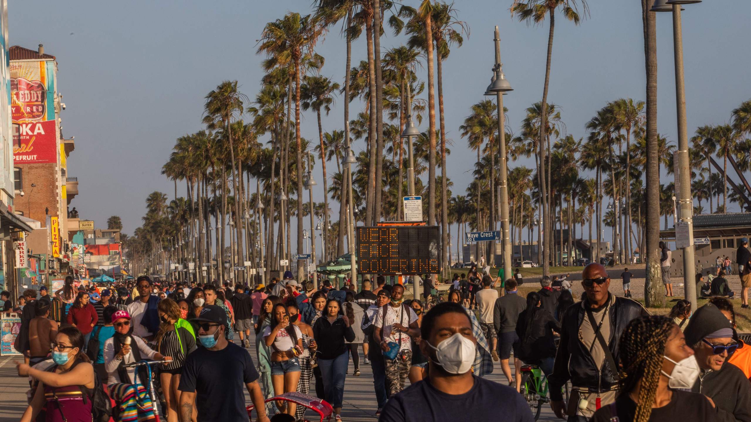 People walk at the boardwalk in Venice Beach during the first day of the Memorial Day holiday weekend amid the COVID-19, pandemic on May 23, 2020. (APU GOMES/AFP via Getty Images)