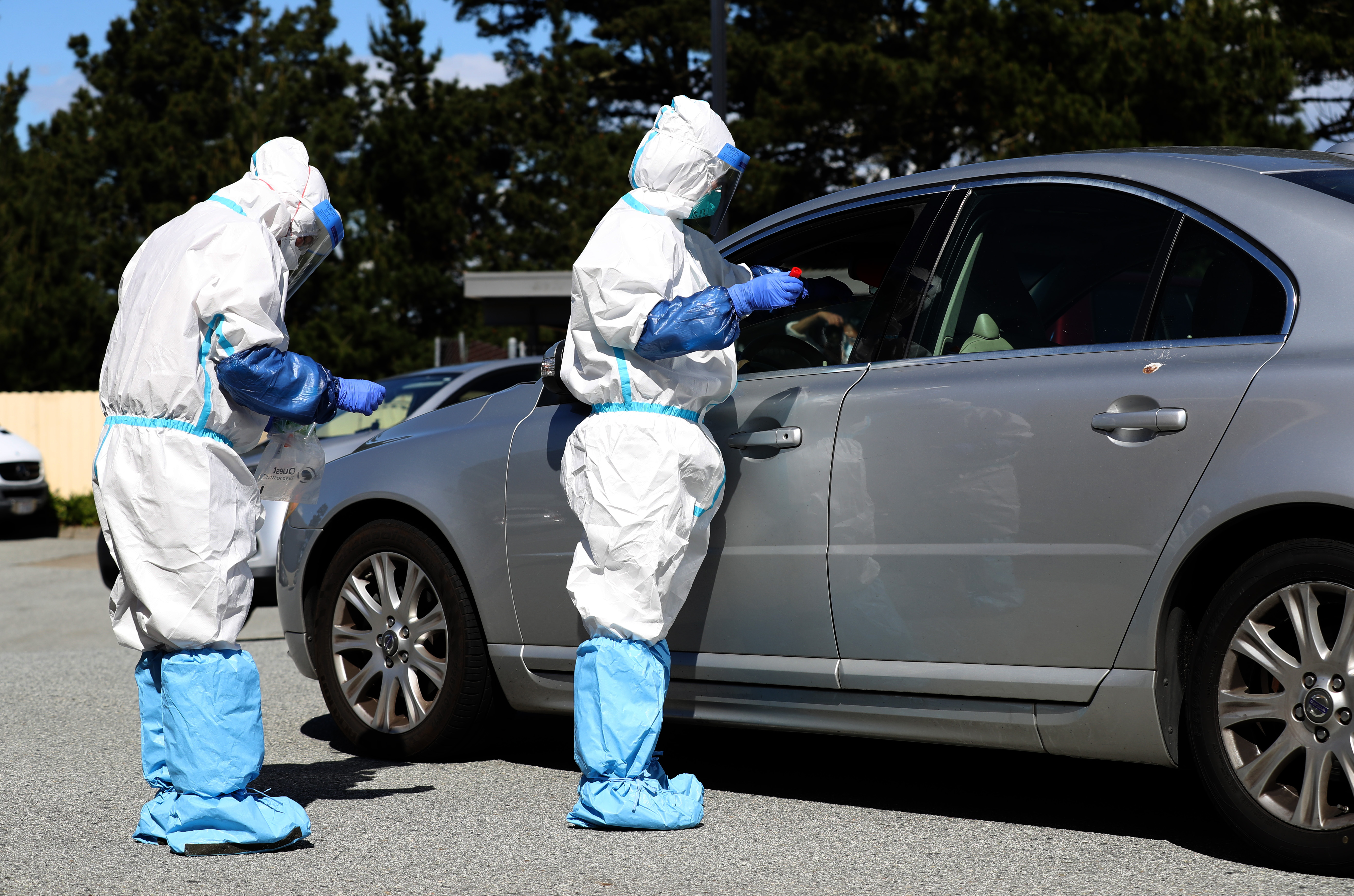 Medical professionals administer a coronavirus test during a drive-thru testing station on March 26, 2020 in Daly City. (Justin Sullivan/Getty Images)