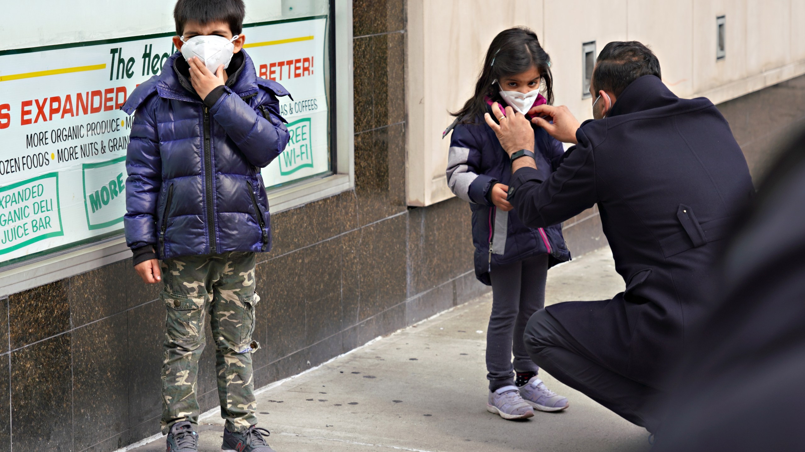 A man adjusts a child's protective mask amid the coronavirus pandemic on April 5, 2020 in New York City. (Cindy Ord/Getty Images)