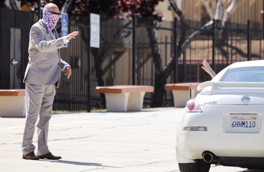 Pastor Jerel Hagerman (L) waves to a departing congregant after conducting a drive-in ‘car church’ Easter service in the parking lot of Joshua Springs Calvary Chapel amidst the coronavirus pandemic on April 12, 2020 in Yucca Valley, California. (Mario Tama/Getty Images)