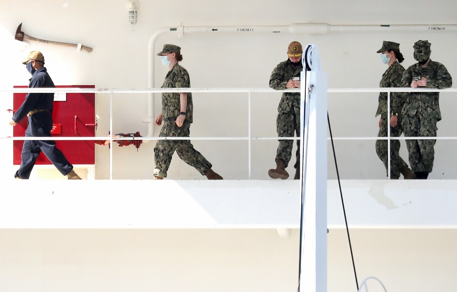 Military personnel walk wearing face masks aboard the USNS Mercy Navy hospital ship docked in the Port of Los Angeles on April 15, 2020. Personnel from the ship will be assisted nursing facilities in the area as they respond to coronavirus outbreaks, Gov. Gavin Newsom announced. (Mario Tama/Getty Images)