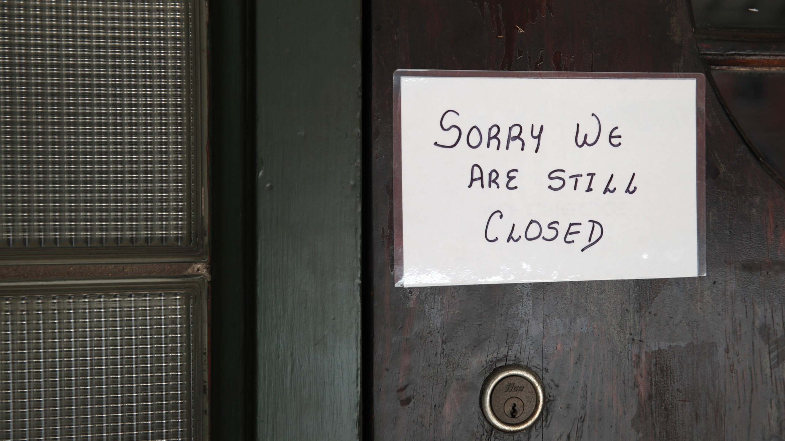 A sign on the door of Flannery's Tavern lets customers know the business is still closed on May 13, 2020, in Chesterton, Indiana. (Scott Olson/Getty Images)