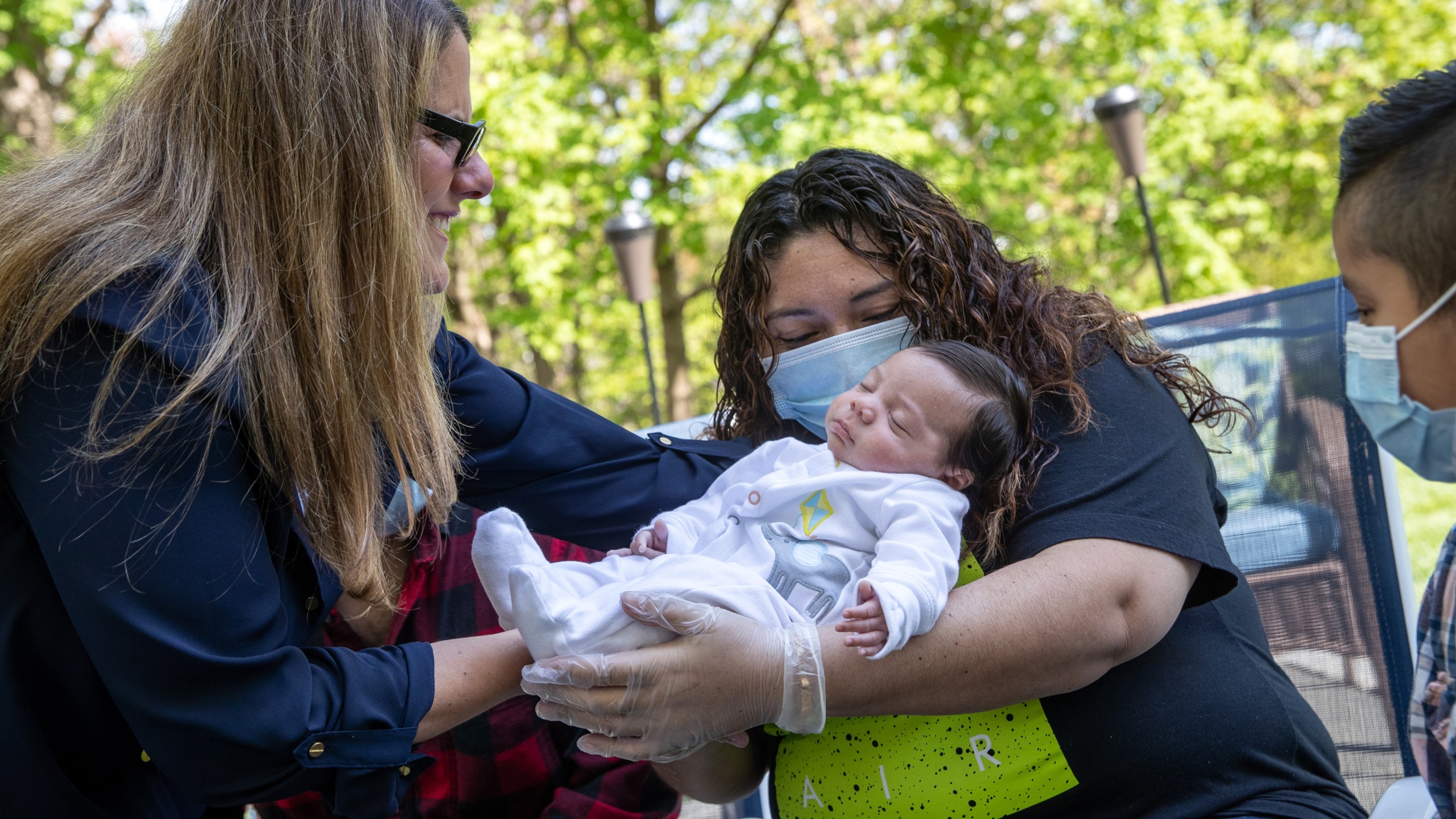 Elementary school teacher Luciana Lira hands Neysel, six weeks, to his mother Zully to hold for the first time on May 14, 2020 in Stamford, Connecticut. Zully and her family, now all testing Covid-negative, met Neysel and brought him home from Lira's house, where she has cared for him since his birth. Zully had tested positive for coronavirus in April 2020. (John Moore/Getty Images)