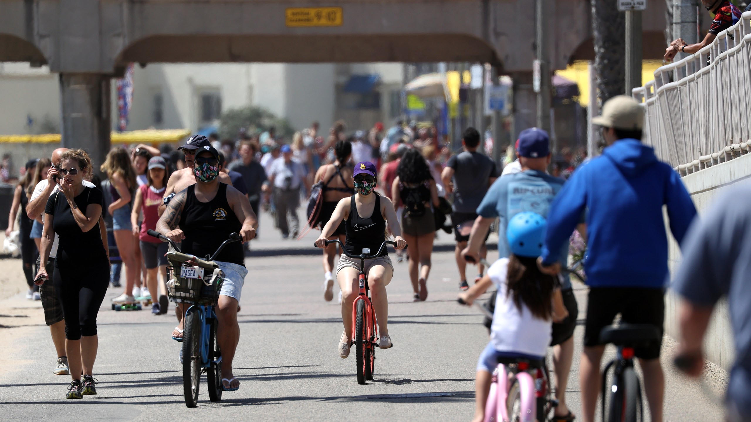 People walk and ride down a path in Huntington Beach on May 15, 2020. (Michael Heiman/Getty Images)