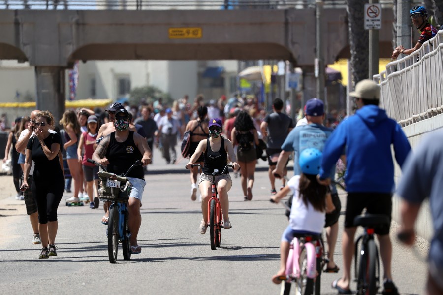 People walk and ride down a path in Huntington Beach on May 15, 2020. (Michael Heiman/Getty Images)