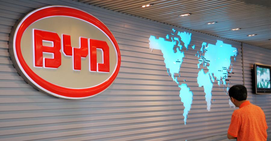 The BYD Auto (Build Your Dreams) logo looms over a scale model of the company's factory in Shenzhen on July 27, 2009. (LAURENT FIEVET/AFP via Getty Images)