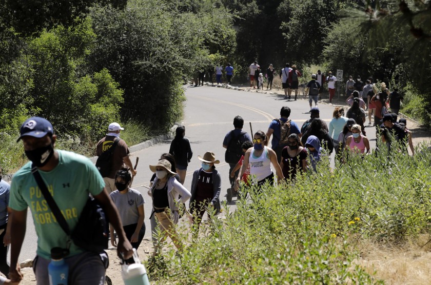 Visitors stream into and out of Eaton Canyon Natural Area on Sunday, which prompted park officials to close trails for the rest of the holiday weekend.(Myung J. Chun / Los Angeles Times)