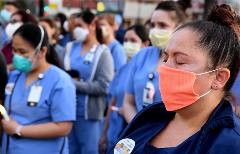 Monique Hernandez, a nurse at Riverside Community Hospital, attends a candlelight vigil for nurse Celia Marcos outside Hollywood Presbyterian Medical Center in Los Angeles on May 6, 2020. Marcos died 14 days after treating a COVID-19 patient without an N95 mask. (Wally Skalij / Los Angeles Times)