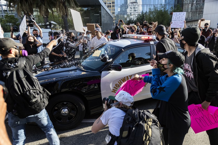 Black Lives Matter protesters swarm a California Highway Patrol vehicle in front of Los Angeles police headquarters on May 28, 2020. (Gina Ferazzi / Los Angeles Times)