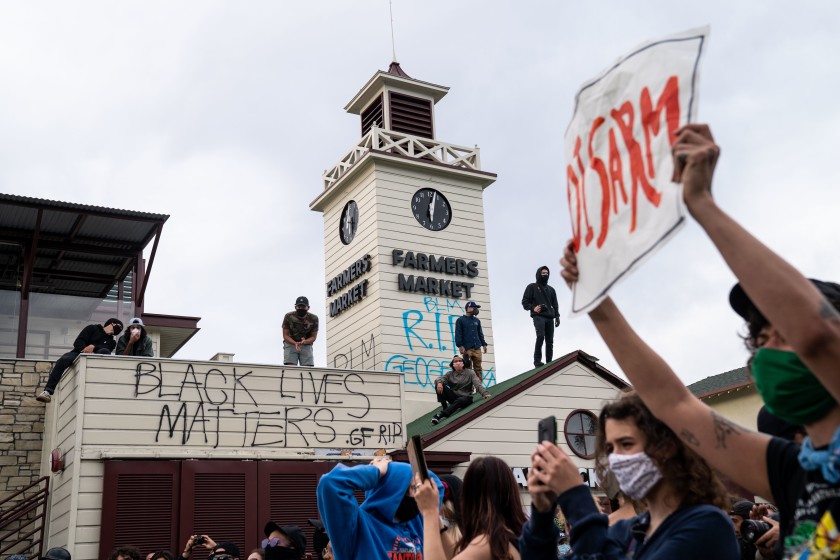 Protesters shout, “Hands up, don’t shoot,” outside The Grove in the Fairfax District on May 30, 2020, after demonstrators outraged over the death of George Floyd in Minneapolis converged on the area. (Kent Nishimura / Los Angeles Times)