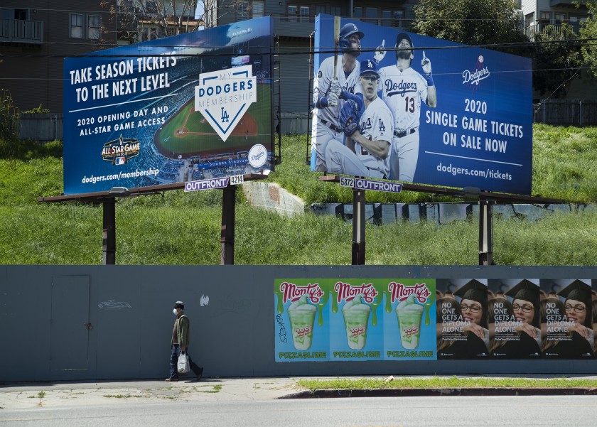 Billboards on Sunset Boulevard near the entrance to Dodger Stadium advertise season tickets and individual game tickets in late March.(Mel Melcon / Los Angeles Times)