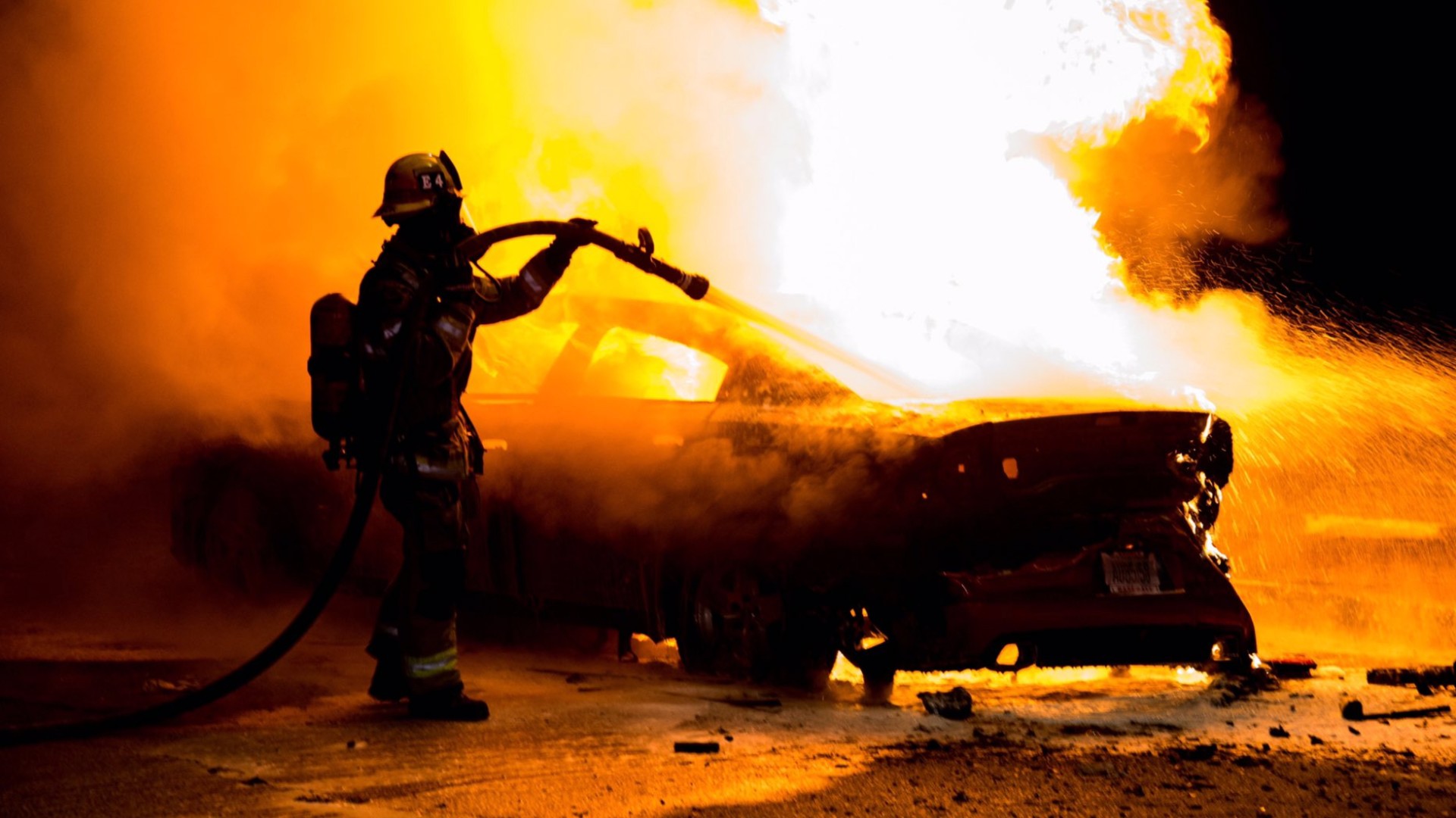 A firefighter works to put out a car fire in Anaheim on May 29, 2020. (Anaheim Police Department)