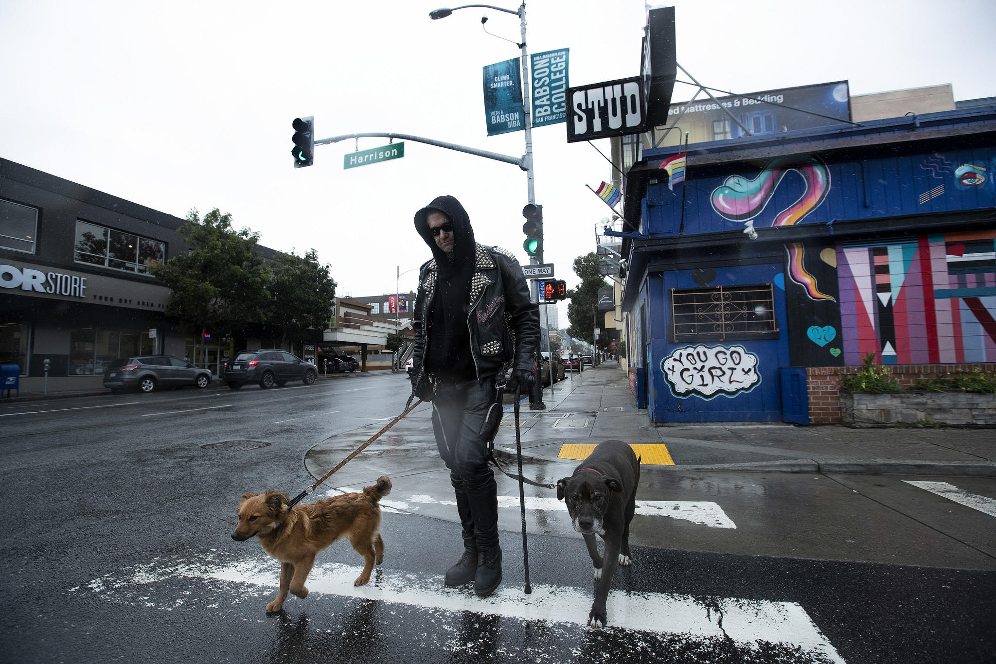 Scott Hulsey walks his dogs, Velouria, left, and Duma, on Ninth Street outside San Francisco’s The Stud bar in 2019. (Mel Melcon / Los Angeles Times)