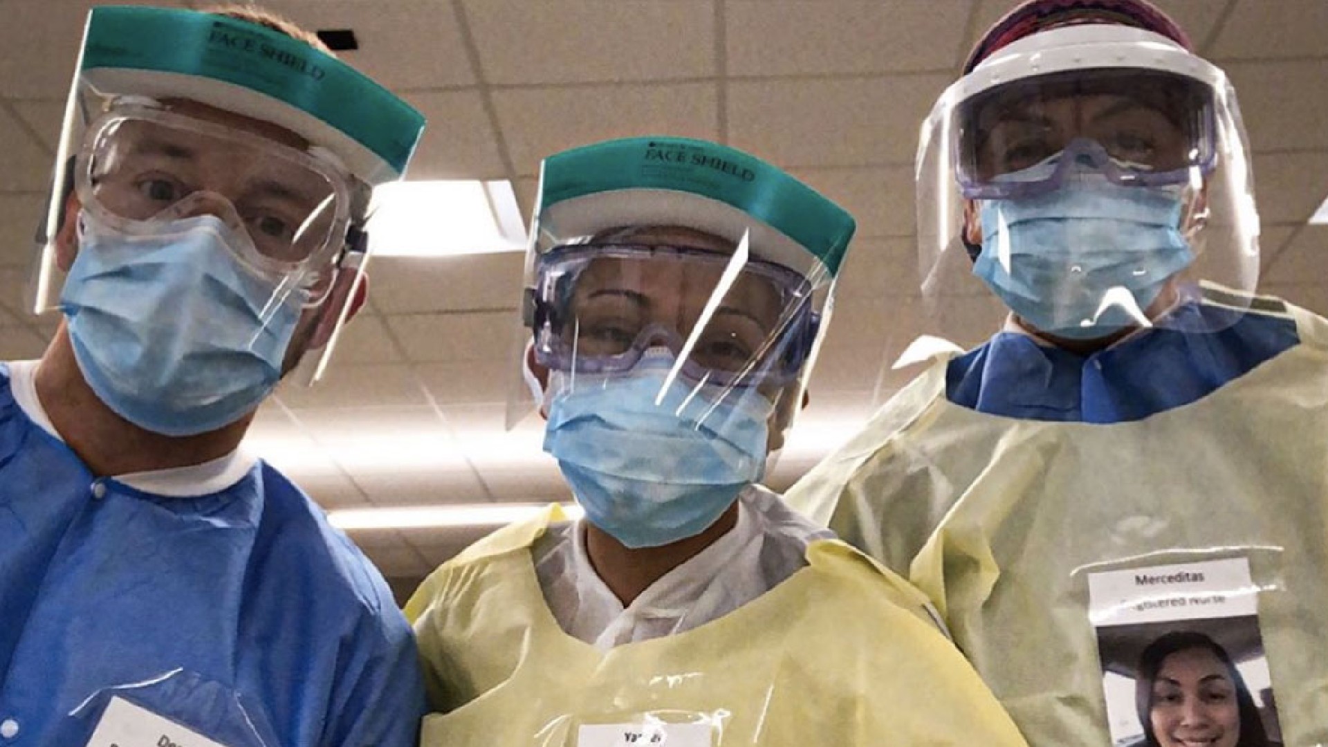 Health care workers wearing photos of themselves outside of their PPE to help put patients at ease. (Derek DeVault)