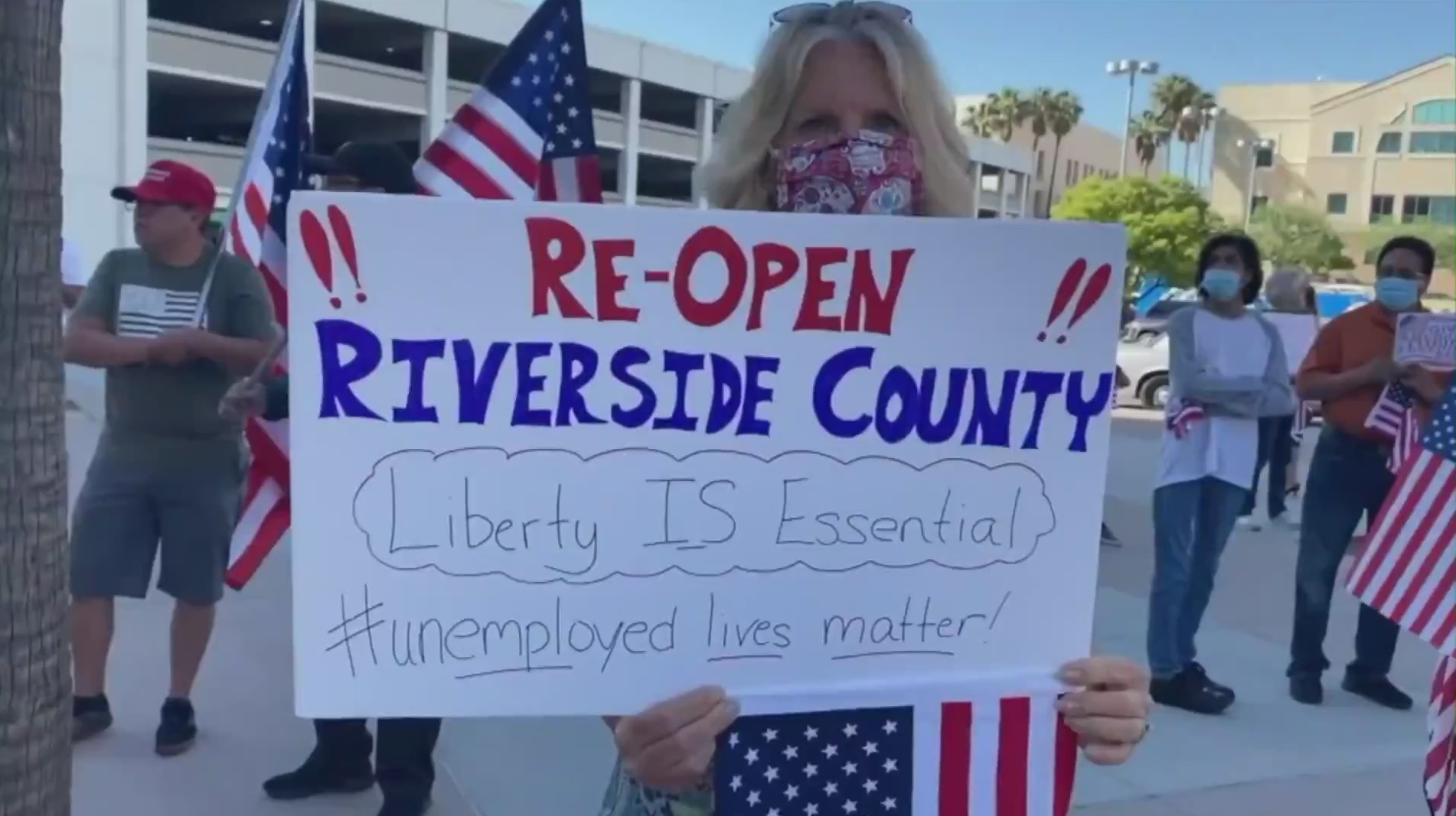 A woman participates in a protest outside the Riverside County Administrative Center while the Board of Supervisors considered lifting some coronavirus restrictions on May 5, 2020. (Credit: KTLA)