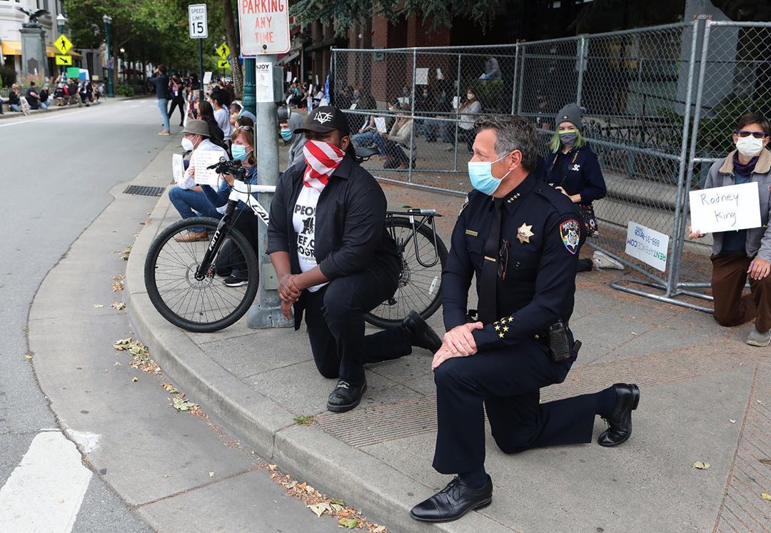 Police Chief Andy Mills takes a knee with protestors in Santa Cruz. (Shmuel Thaler)