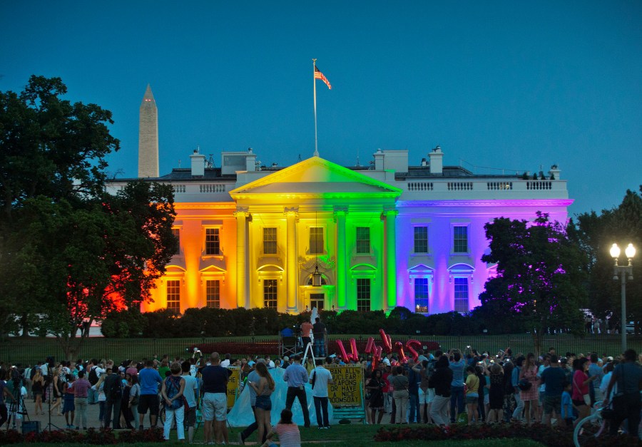 In this Friday, June 26, 2015 file photo, people gather in Lafayette Park to see the White House illuminated with rainbow colors in commemoration of the Supreme Court's ruling to legalize same-sex marriage in Washington. The Trump administration Friday, June 12, 2020, finalized a regulation that overturns Obama-era protections for transgender people against sex discrimination in health care. (AP Photo/Pablo Martinez Monsivais, File)