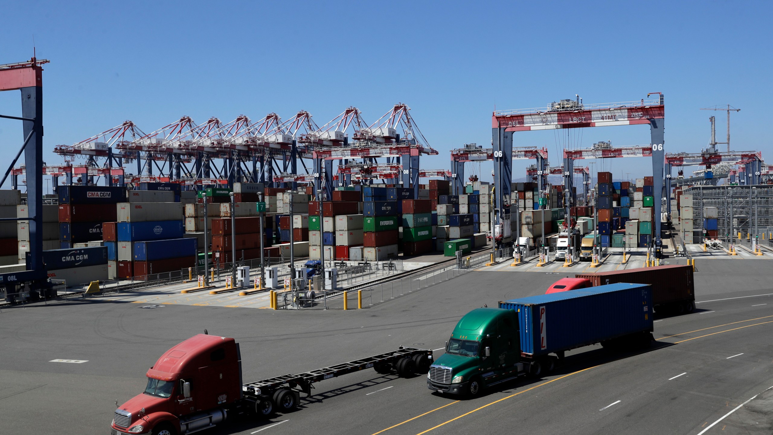 Trucks travel along a loading dock at the Port of Long Beach on Aug. 22, 2018. (AP Photo/Marcio Jose Sanchez, File)