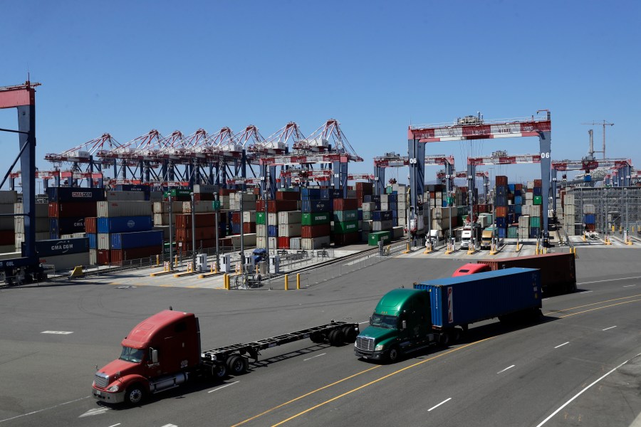 Trucks travel along a loading dock at the Port of Long Beach on Aug. 22, 2018. (AP Photo/Marcio Jose Sanchez, File)