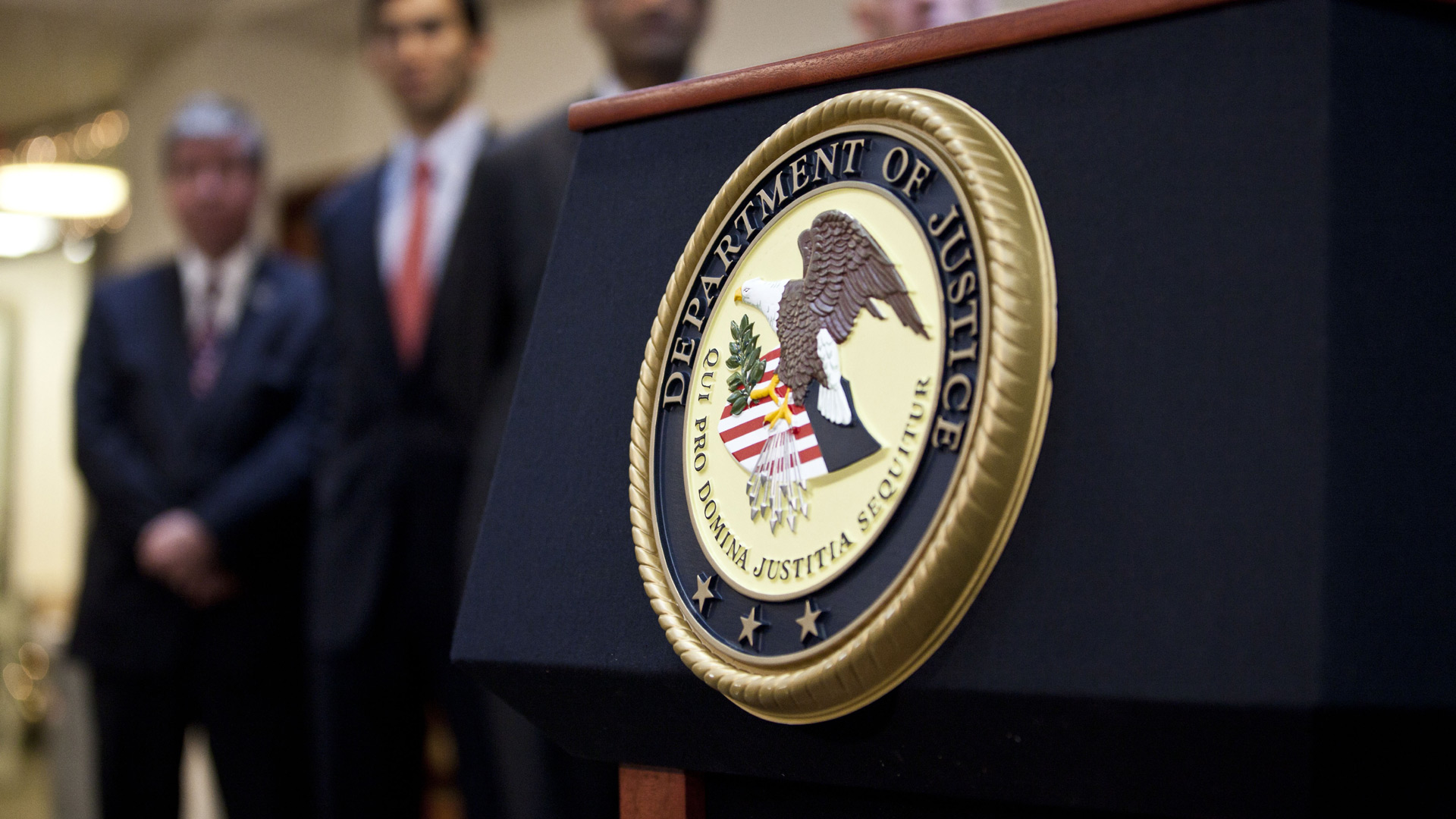 A U.S. Department of Justice seal is displayed on a podium during a news conference. (Ramin Talaie/Getty Images)