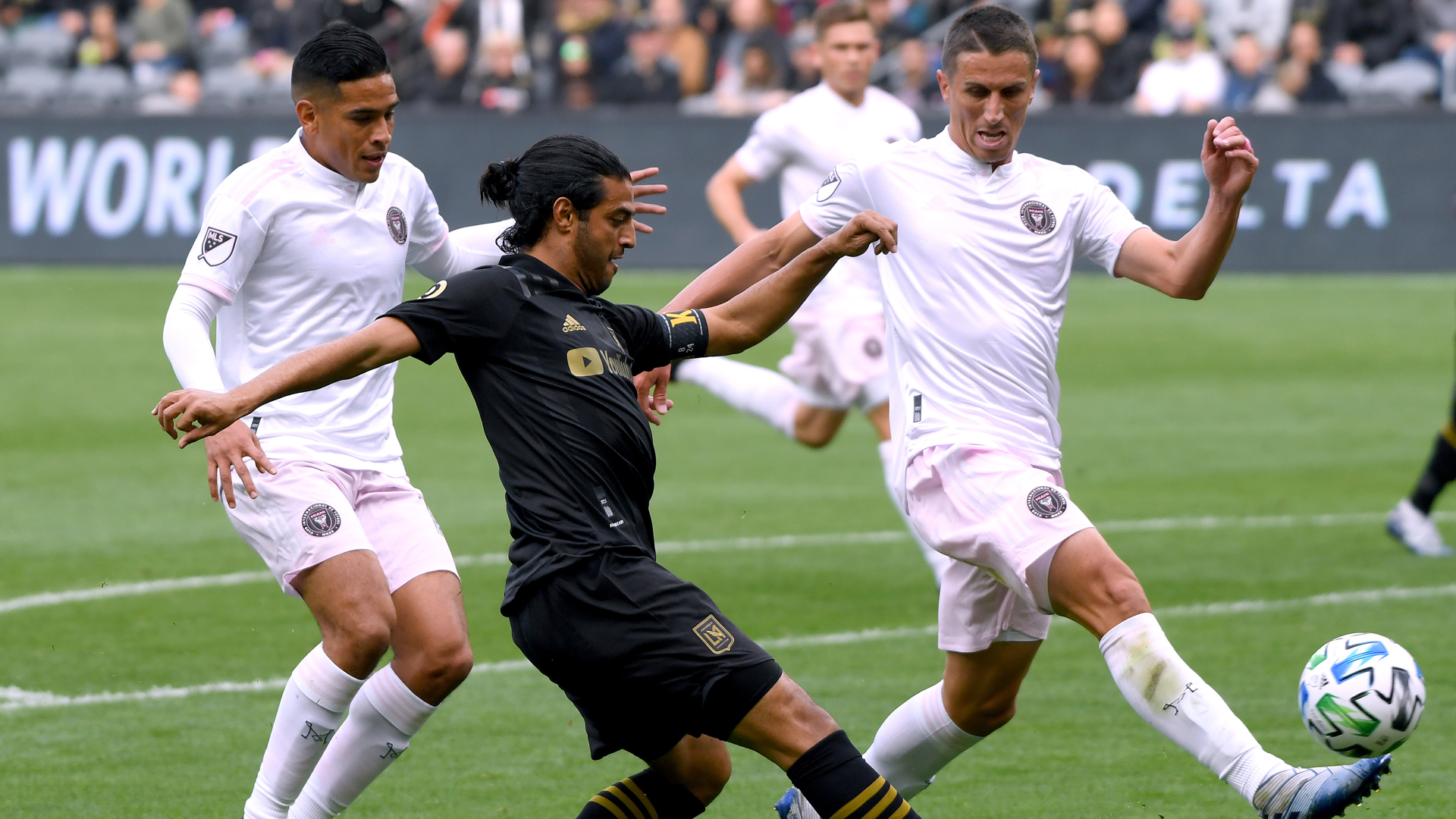 Carlos Vela #10 of Los Angeles FC attempts a cross in front of Victor Ulloa #13 and Ben Sweat #22 of Inter Miami CF during the first half at Banc of California Stadium on March 1, 2020. (Harry How/Getty Images)