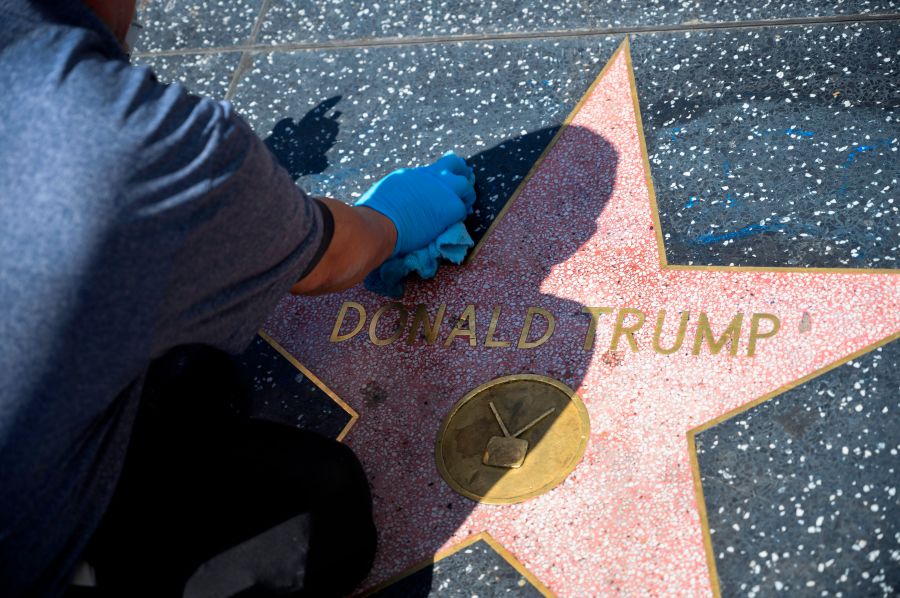 A maintenance worker uses cleaning product to remove graffiti after Donald Trump's star on the Hollywood Walk of Fame was defaced on April 23, 2020 (ROBYN BECK/AFP via Getty Images)