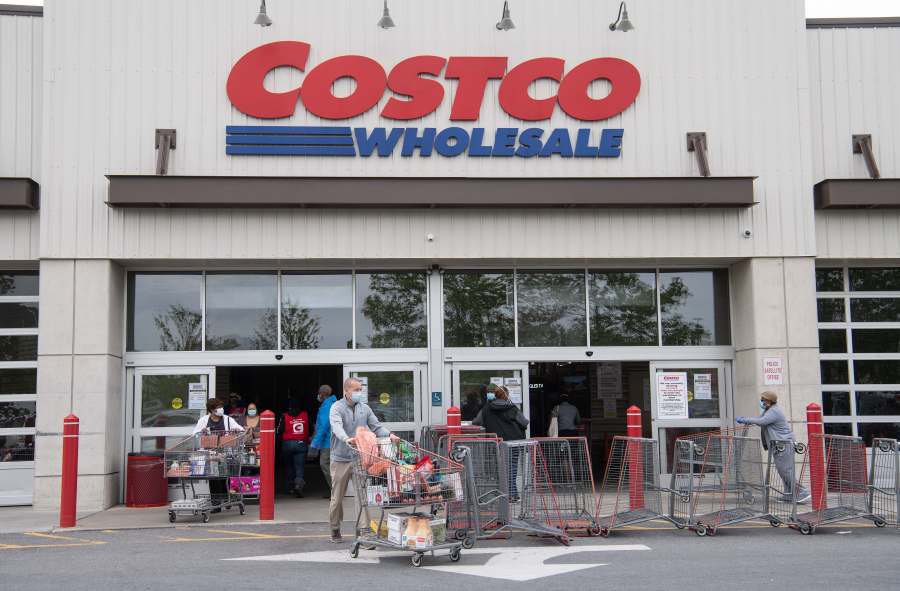 Shoppers walk out with full carts from a Costco store in Washington, DC, on May 5, 2020. (NICHOLAS KAMM/AFP via Getty Images)