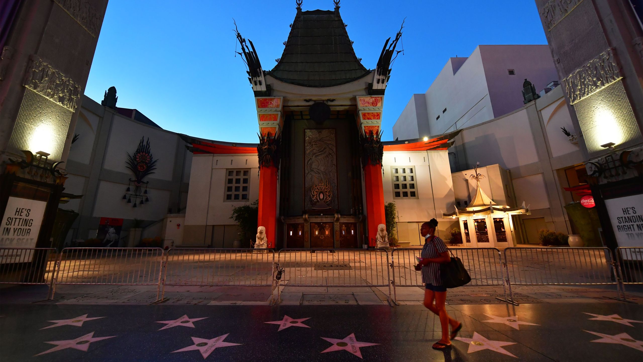 A woman walks past the closed courtyard in front of the TCL Chinese Theater on May 5, 2020 in Hollywood.(FREDERIC J. BROWN/AFP via Getty Images)