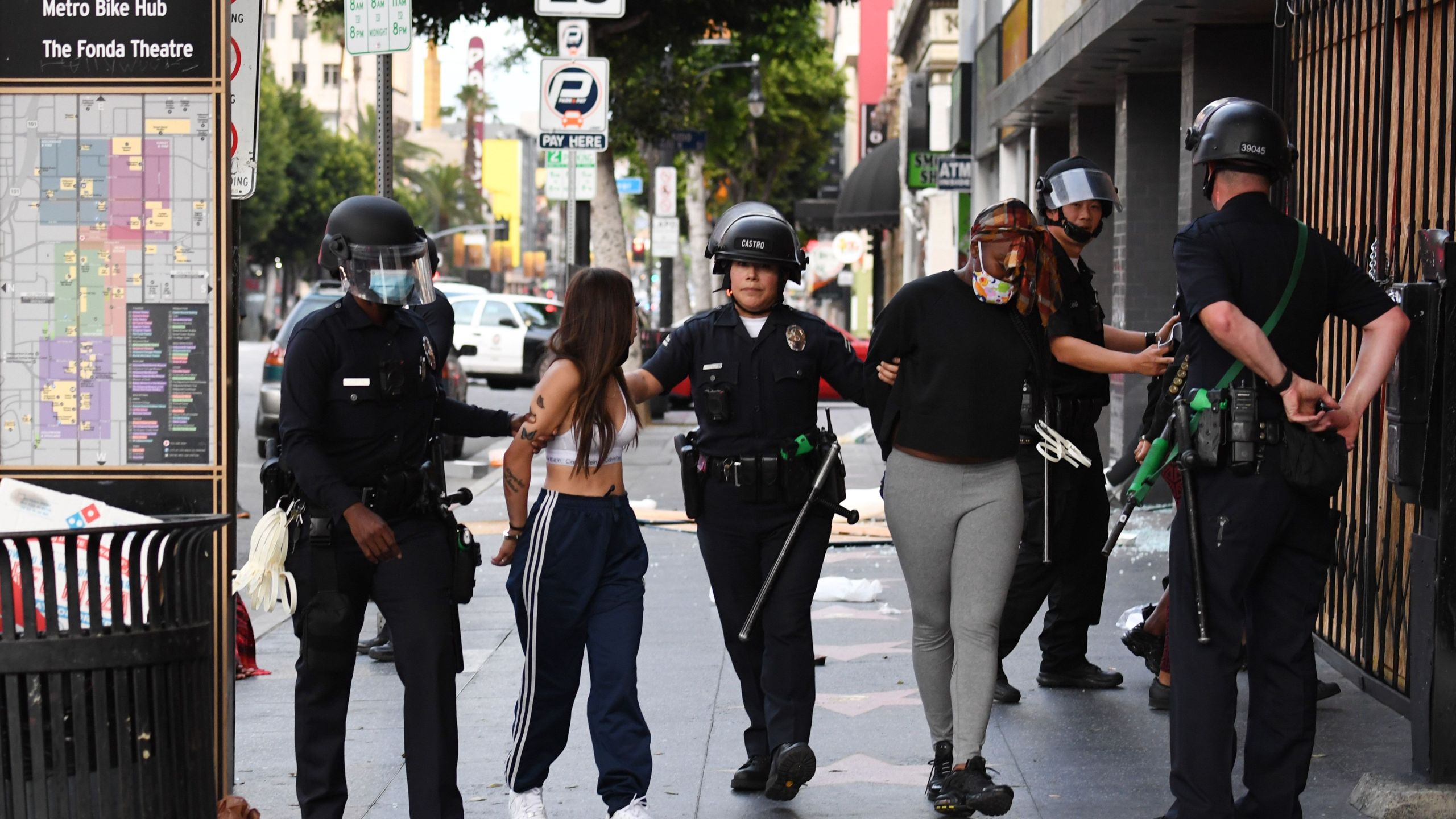 Police officers arrest people after a store was looted in Hollywood on June 1, 2020, after a third day of protests and looting throughout California. (ROBYN BECK/AFP via Getty Images)