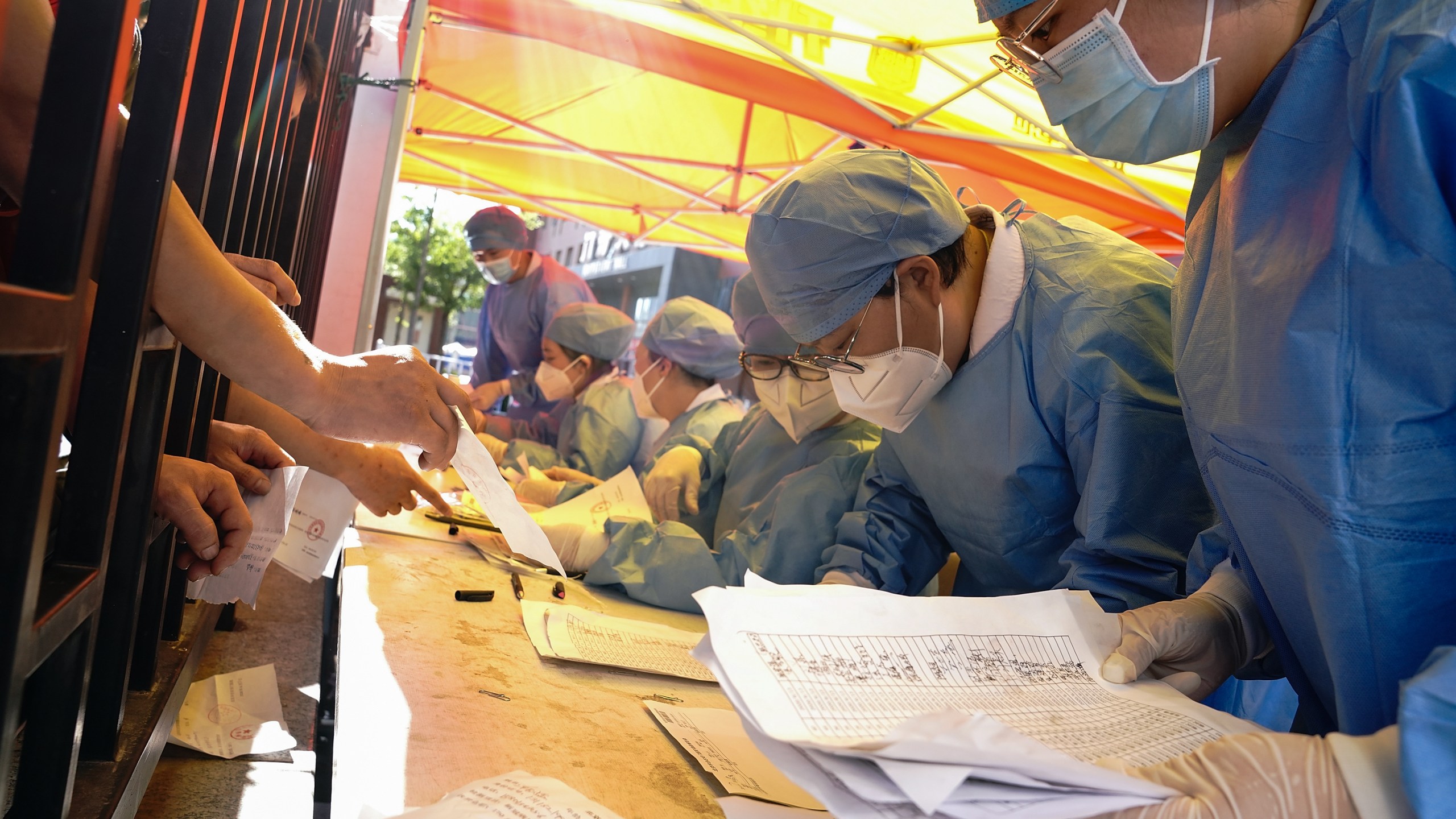 Medical workers wearing protective suits sort nucleic acid test results for the citizens at a hospital on June 14, 2020 in Beijing, China. (Lintao Zhang/Getty Images)