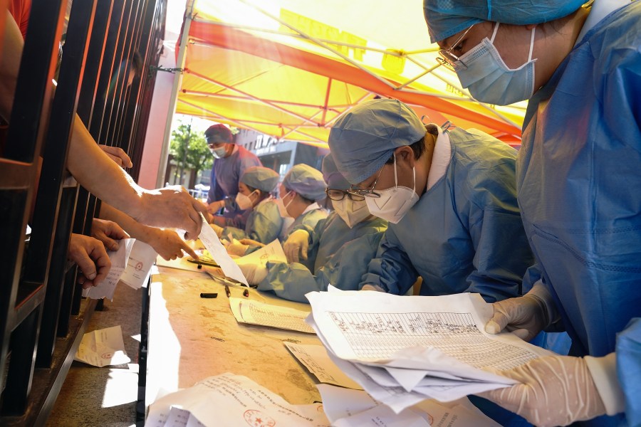 Medical workers wearing protective suits sort nucleic acid test results for the citizens at a hospital on June 14, 2020 in Beijing, China. (Lintao Zhang/Getty Images)