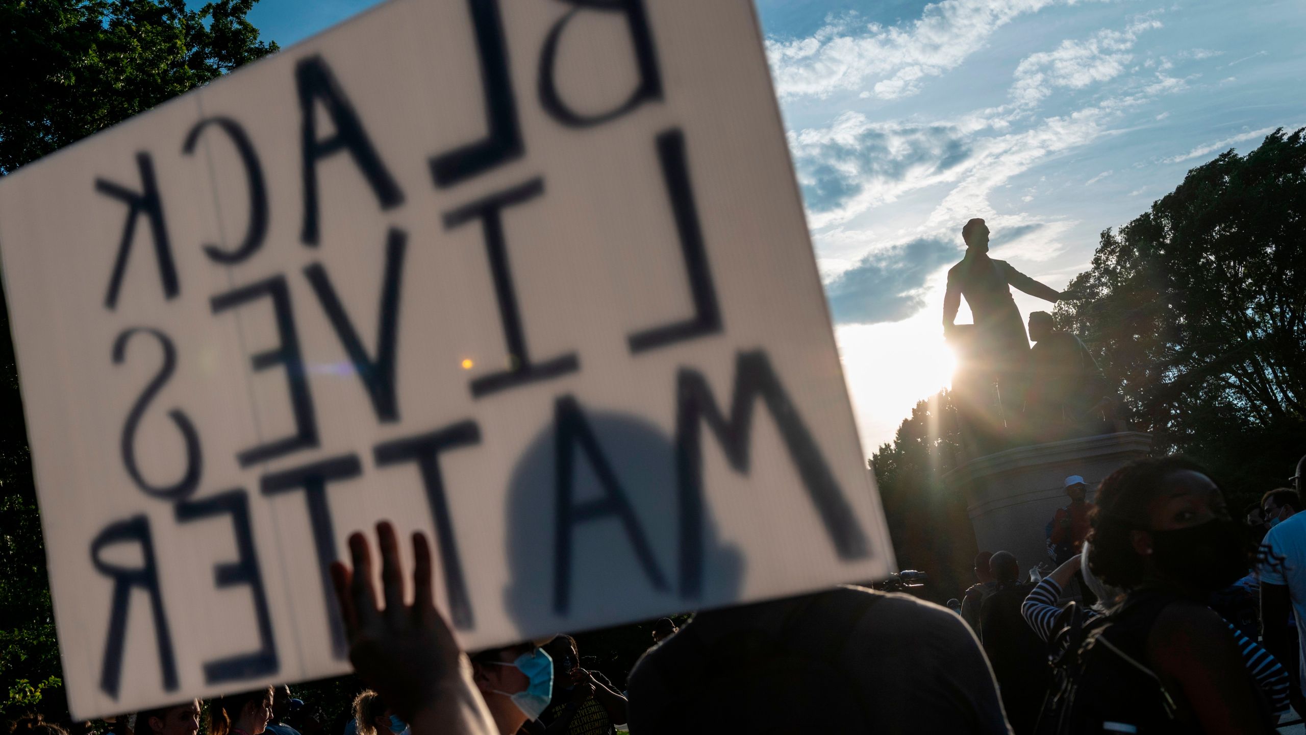 Protesters hold signs during a rally in support of the removal of the Emancipation Statue at Lincoln Park in Washington, D.C., on June 23, 2020. (Roberto Schmidt / AFP / Getty Images)