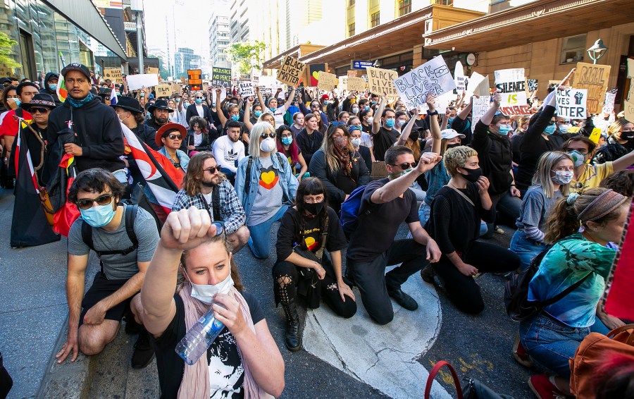 People kneel in the CBD on June 6, 2020 in Brisbane, Australia. Events across Australia have been organized in solidarity with protests in the United States following the killing of an unarmed black man George Floyd at the hands of a police officer in Minneapolis, Minnesota and to rally against aboriginal deaths in custody in Australia. (Jono Searle/Getty Images)