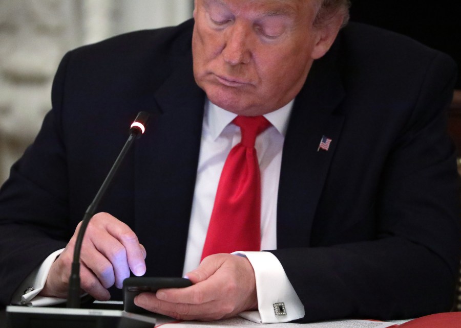 Donald Trump uses his phone during a roundtable at the State Dining Room of the White House on June 18, 2020, in Washington, DC. (Alex Wong/Getty Images)