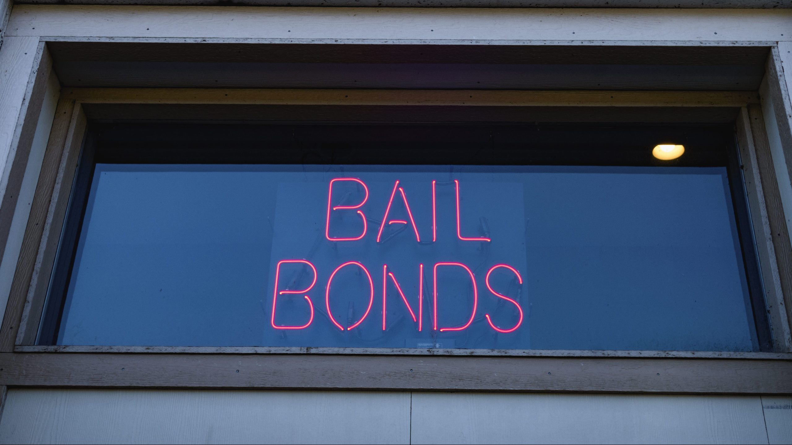 A neon bail bond sign is seen in a window. (Getty Images)