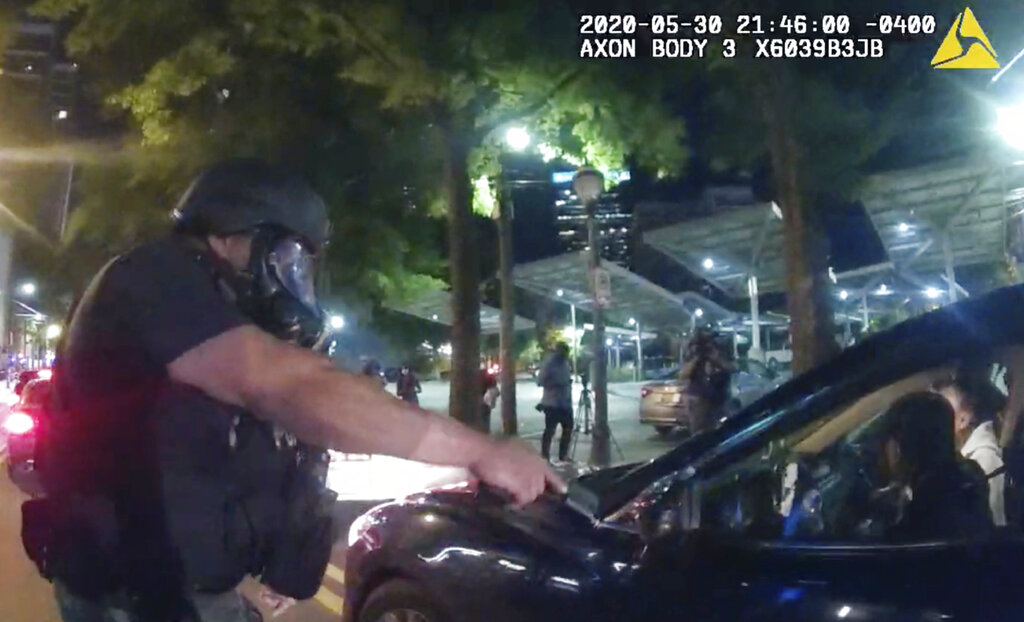 In body camera video released by the Atlanta Police Department, an officer points his handgun at Messiah Young while the college student is seated in his vehicle on May 30, 2020. (Atlanta Police Department via AP)