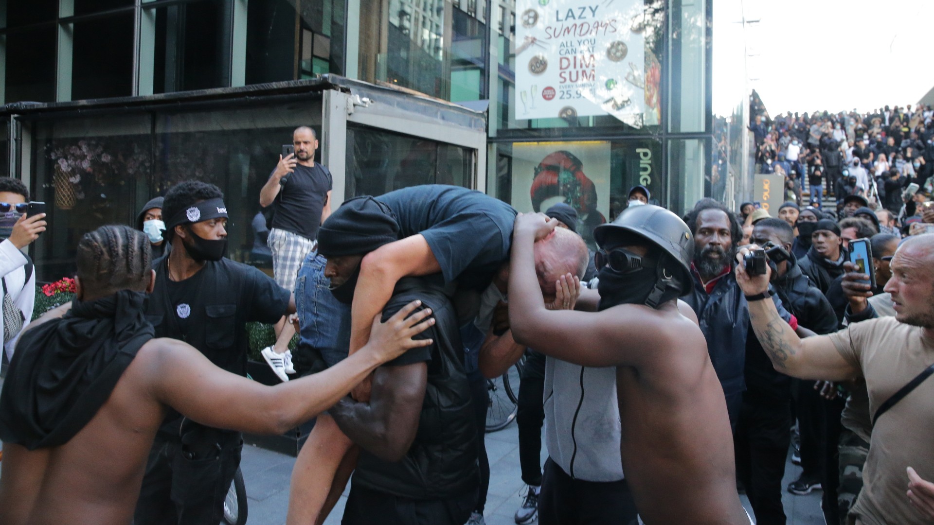 A group of men including Patrick Hutchinson (carrying the man) help an injured man away after he was allegedly attacked by some of the crowd of protesters on the Southbank near Waterloo station on June 13, 2020 in London, United Kingdom. (Luke Dray/Getty Images)