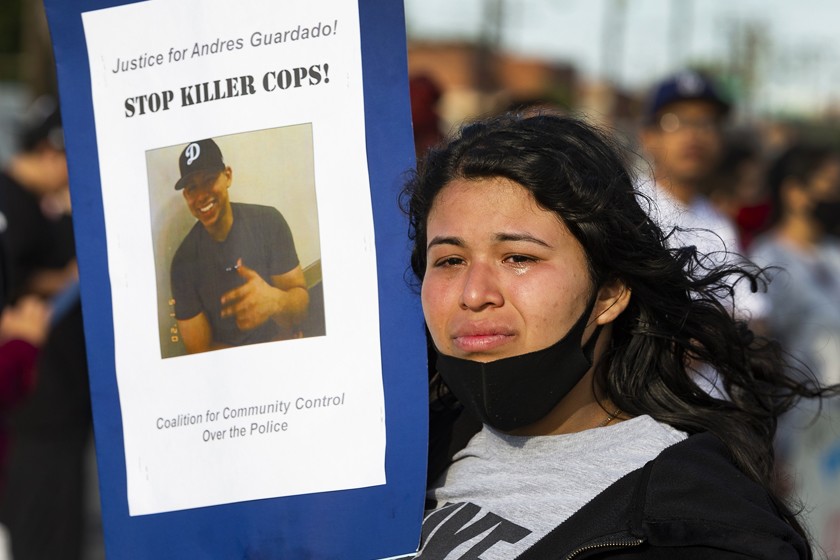 A photo of 18-year-old Andres Guardado is held by his 22-year-old sister, Jennifer, during a rally last week in Gardena. He was fatally shot June 18 by a sheriff’s deputy.(Damian Dovarganes / Associated Press)