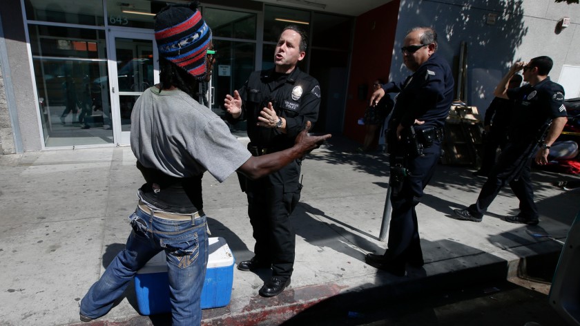 Los Angeles police officers talk to a homeless man on San Pedro Street along Skid Row in this undated photo. (Mark Boster / Los Angeles Times)