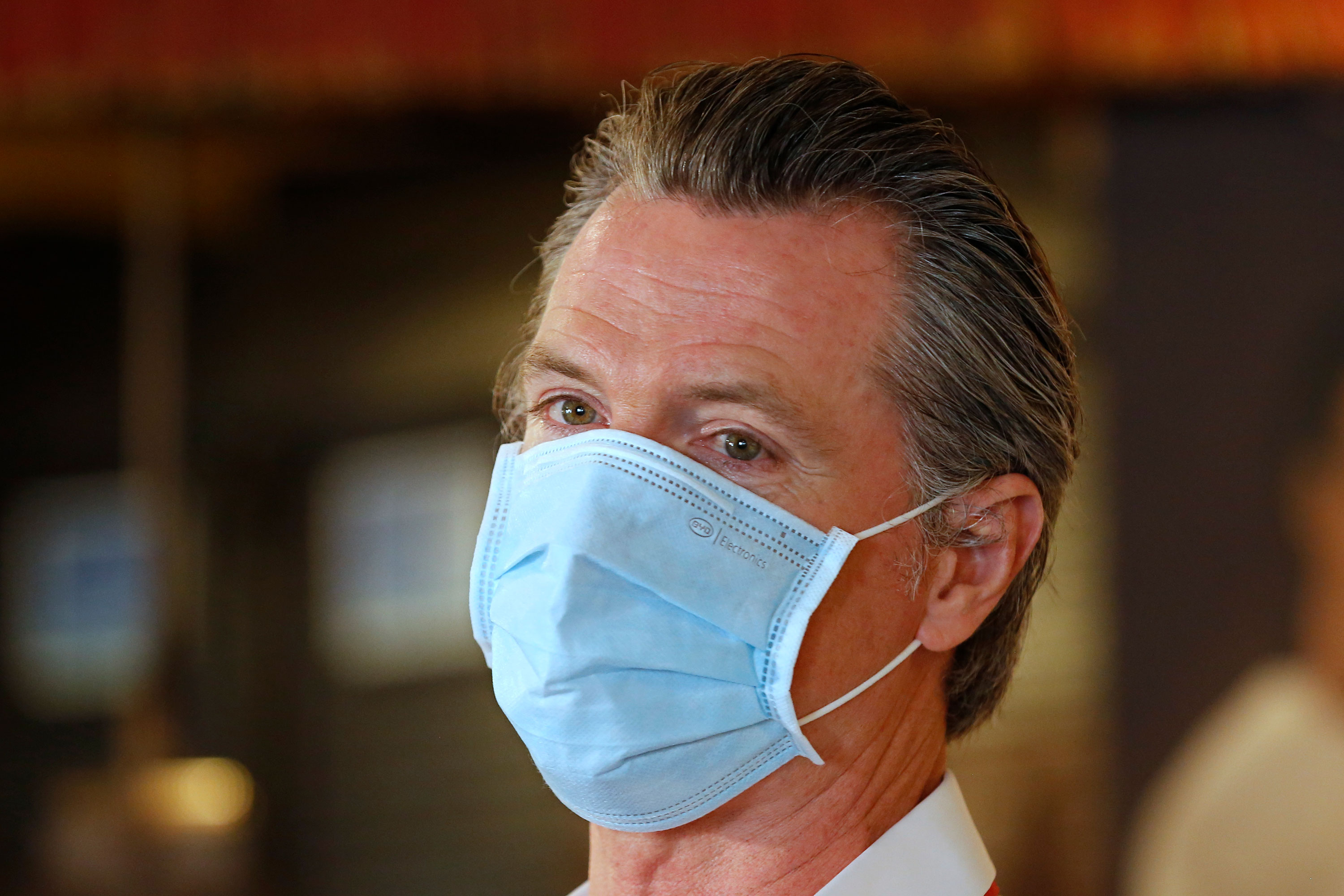 Gov. Gavin Newsom wears a face mask as he answers a reporter's question during his visit to the Queen Sheba Ethiopian Cuisine restaurant, in Sacramento on June 19, 2020. (AP Photo/Rich Pedroncelli, Pool via CNN)