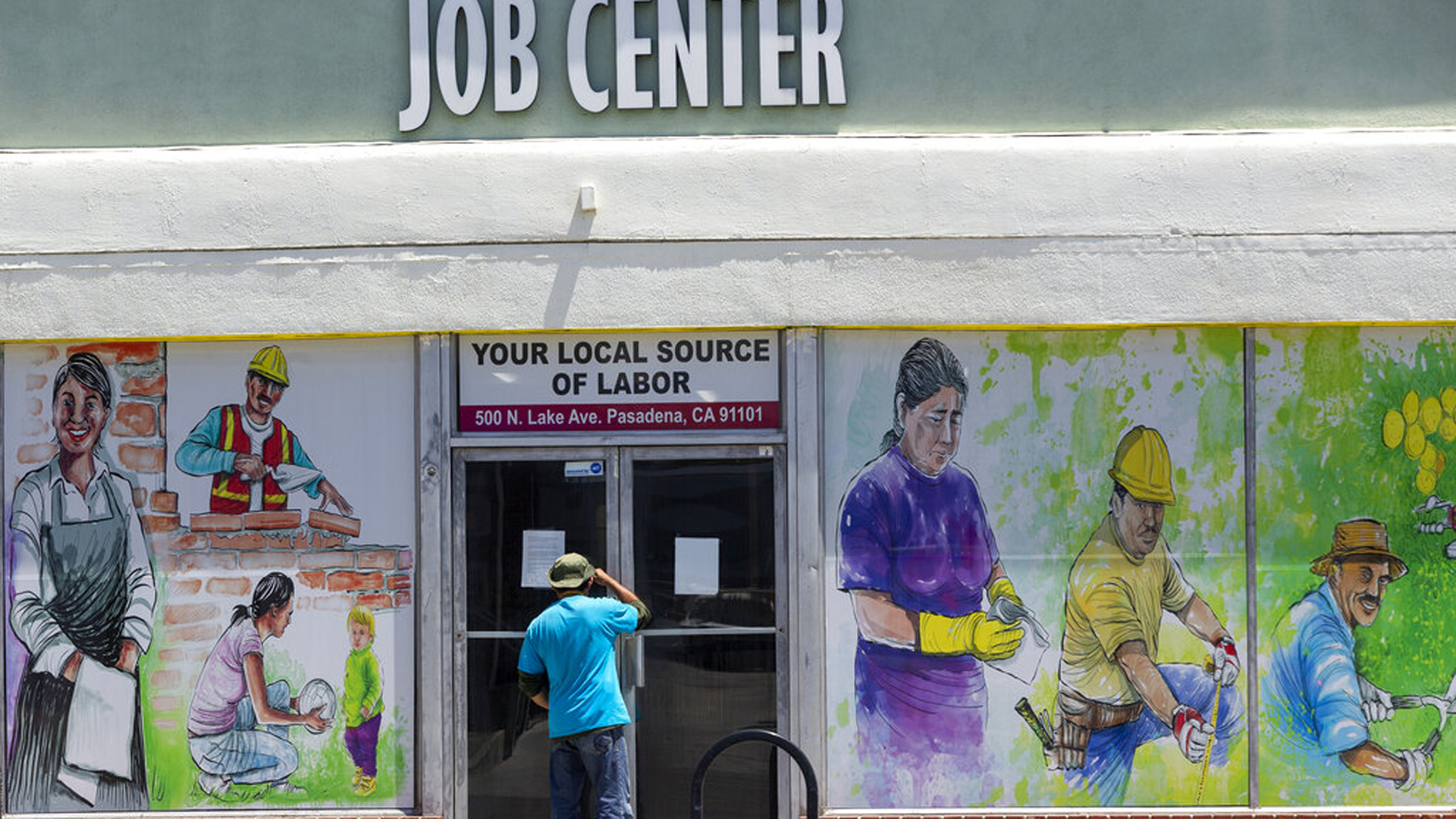 A person looks inside the closed doors of the Pasadena Community Job Center on May 7, 2020. (Damian Dovarganes / Associated Press)