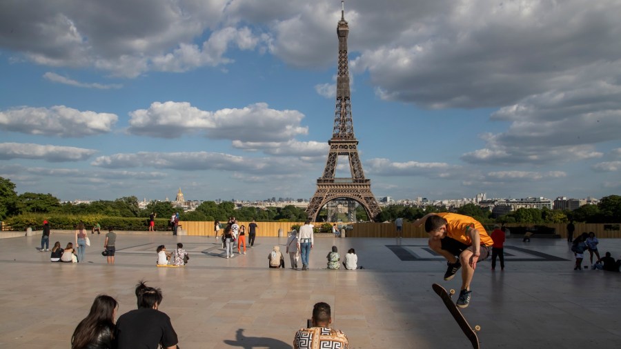 In this Monday, May 25, 2020 file photo, people stroll at Trocadero square near the Eiffel Tower in Paris. (AP Photo/Michel Euler, File)