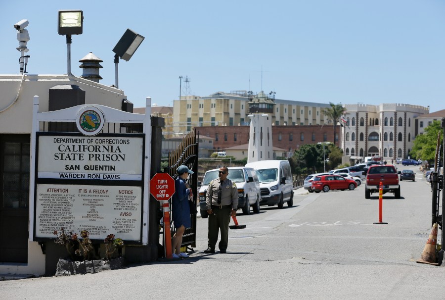 A Department of Corrections officer guards the main entryway leading into San Quentin State Prison on July 24, 2019. (AP Photo/Eric Risberg, File)