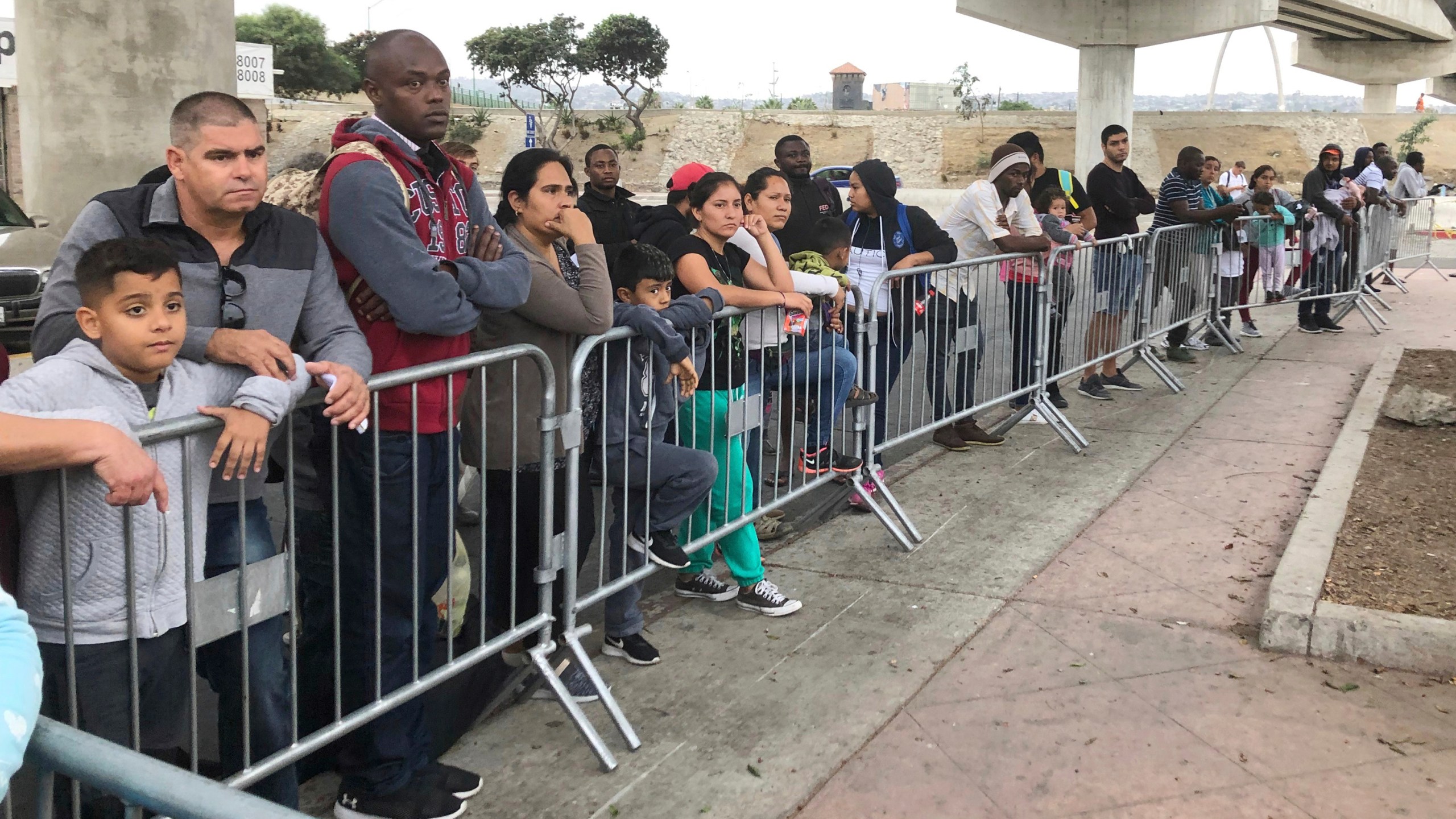 Asylum seekers in Tijuana, Mexico, listen to names being called from a waiting list to claim asylum at a border crossing in San Diego on Sept. 26, 2019. (AP Photo/Elliot Spagat,File)