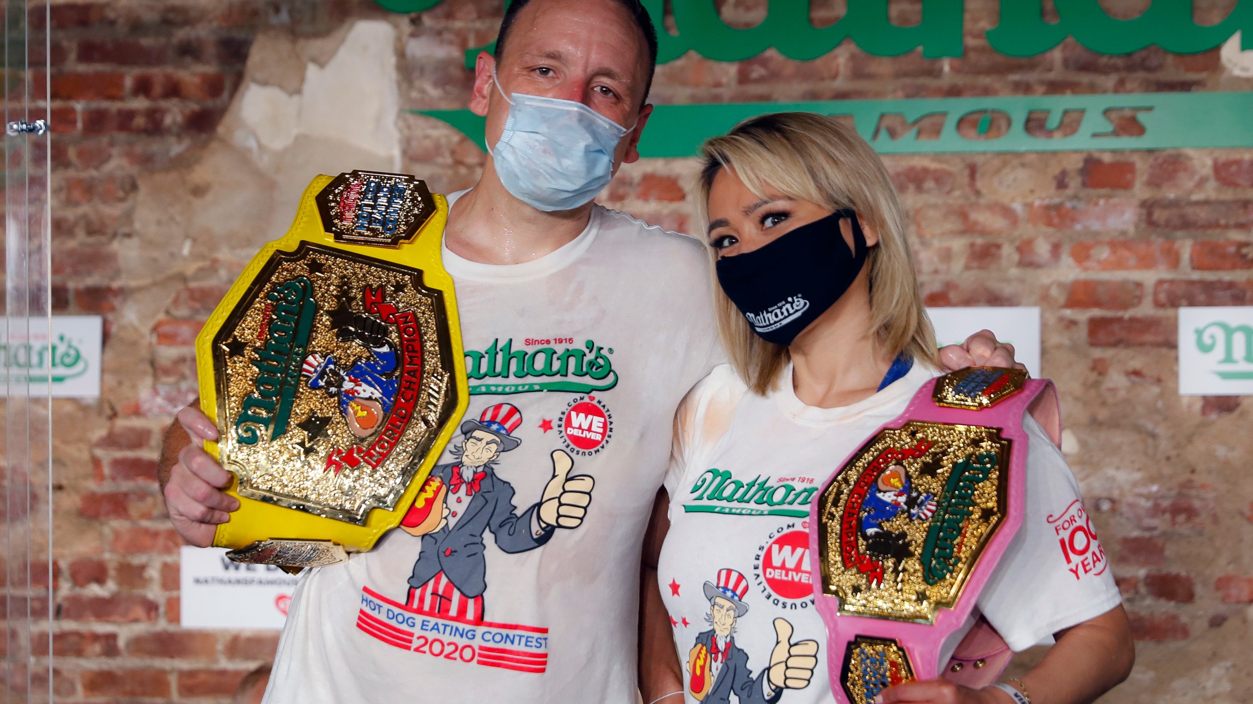 Competitive eaters Joey Chestnut, left, and Miki Sudo, right, pose for a photograph after winning their respective divisions with new world records after the Nathan's Famous July Fourth hot dog eating contest, Saturday, July 4, 2020, in the Brooklyn borough of New York. (AP Photo/John Minchillo)