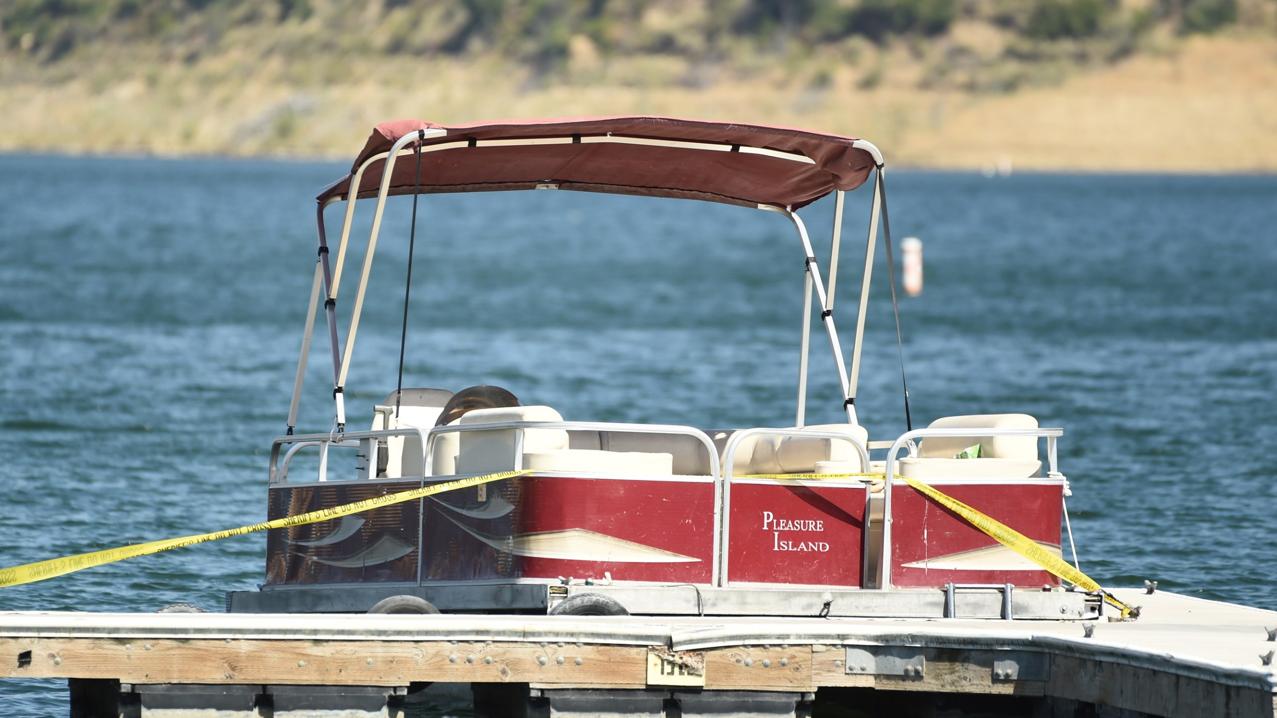 A boat covered in caution tape rented by "Glee" actress Naya Rivera sits at a dock while members of Ventura County Sheriff's Office Underwater Search and Rescue Team search for the actress on Thursday, July 9, 2020, at Lake Piru in Los Padres National Forest, northwest of Los Angeles. (AP Photo/Chris Pizzello)